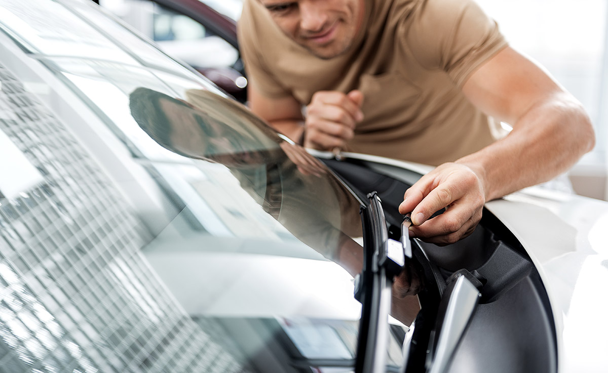 man inspecting windshield wiper